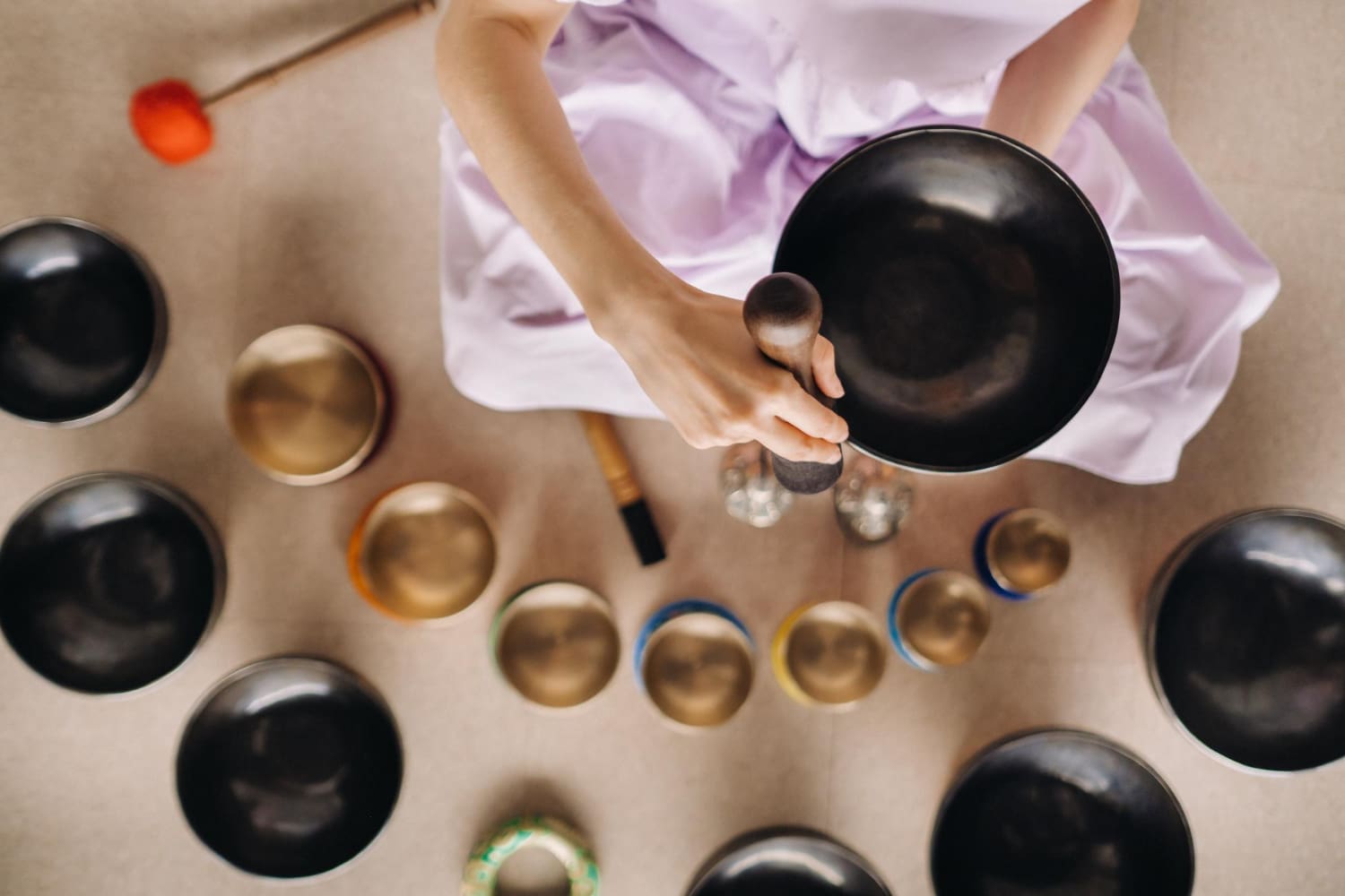 Hands playing arranged Tibetan singing bowls