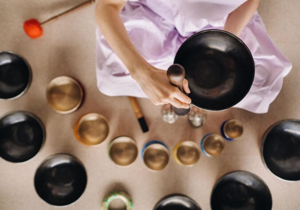 Hands playing arranged Tibetan singing bowls